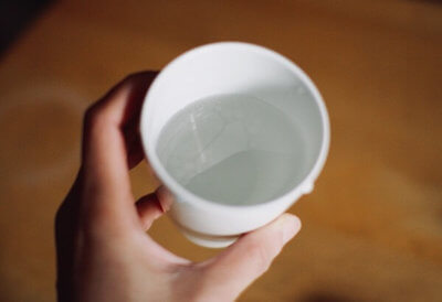 コップの水にオレガノオイルを1滴垂らしたコップ