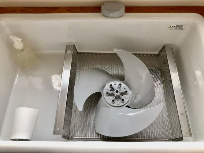 洗面所で換気扇の部材を洗う